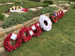 Nine memorial wreaths laid at the gravesite of John McCrae. Many are made out of poppies except for the centre wreath which is white paper with notes of remembrance from Canadians.