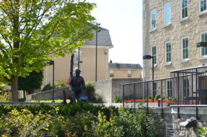 Bronze statue of John McCrae by sculptor Ruth Abernethy sits on the patio of the Civic Museum. The stone building can be seen in the background