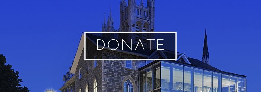 Exterior photo of the Civic Museum at dusk. The sky is deep blue. Donate is written in white text in the centre within a white border