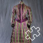 Collection photo of a green and purple tartan dress. There is a puzzle piece outline at the bottom right of the photo.