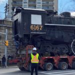 Locomotive 6167 Tender being transported by flatbed through the intersection of Woolwich Street and Carden Street.