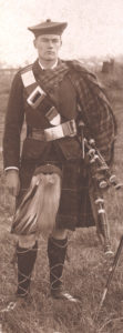 Young bagpipe player in highland costume.