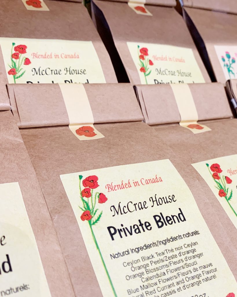 McCrae House loose leaf tea. Brown bags of tea are stacked with their labels facing outwards. 